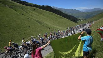 The pack of riders (peloton) cycles in the ascent of the Col de Peyresourde during the 15th stage of the 111th edition of the Tour de France cycling race, 197,7 km between Loudenvielle and Plateau de Beille, in the Pyrenees mountains, southwestern France, on July 14, 2024. 
Marco BERTORELLO / AFP