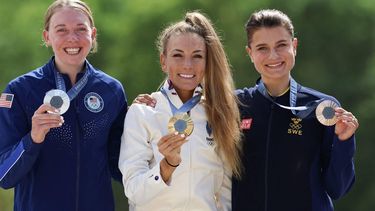 (From L) Silver medallist US' Haley Batten, gold medallist France's Pauline Ferrand Prevot and bronze medallist Sweden's Jenny Rissveds celebrate on the podium after the women's cross-country mountain biking event during the Paris 2024 Olympic Games in Elancourt Hill venue in Elancourt, on July 28, 2024.  
Emmanuel DUNAND / AFP