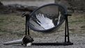 This photograph shows a parabolic mirror reflecting the sun's rays used to light the Olympic torch during the lighting ceremony for the Paris 2024 Olympics Games at the Ancient Olympia archeological site, birthplace of the ancient Olympics in southern Greece, on April 16, 2024. 
Aris MESSINIS / AFP