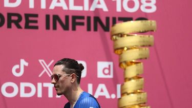 Groupama-FDJ's French rider David Gaudu walks past the Giro d'Italia trophy (“trofeo senza fine”) prior to the first stage of the 108th Giro d'Italia cycling race, 160km from Durres to Tirana in Albania, on May 9, 2025. 
Luca Bettini / AFP