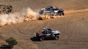 Team Audi Sport's Spanish driver Carlos Sainz and his Spanish co-driver Lucas Cruz steer their car (top) as Team Audi Sport's French driver Stephane Peterhansel and his French co-driver Edouard Boulanger wait for them during the stage 11 of the 2024 Dakar Rally between Al-Ula and Yanbu, Saudi Arabia, on January 18, 2024. 
PATRICK HERTZOG / AFP