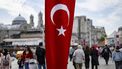 Pedestrians walk past a Turkish national flag on Istiklal Avenue in Istanbul on October 29, 2023, during celebrations to mark the 100th anniversary of the Turkish Republic.  Turkey marked its centenary as a post-Ottoman republic on October 29, 2023 with somewhat muted celebrations held in the shadow of Israel's escalating war with Hamas militants in Gaza.
YASIN AKGUL / AFP