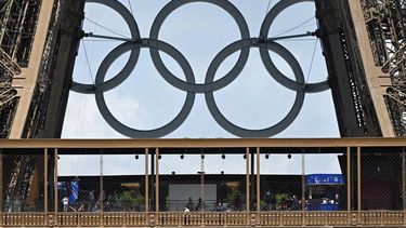 The Olympic rings are seen on the structure of the landmark as people walk on the first floor of The Eiffel Tower in Paris on July 24, 2024, ahead of the Paris 2024 Olympic Games. 
MAURO PIMENTEL / AFP