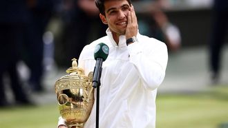 Spain's Carlos Alcaraz holds the winner's trophy as he delivers a speech following his victory against Serbia's Novak Djokovic during their men's singles final tennis match on the fourteenth day of the 2024 Wimbledon Championships at The All England Lawn Tennis and Croquet Club in Wimbledon, southwest London, on July 14, 2024. Defending champion Alcaraz beat seven-time winner Novak Djokovic in a blockbuster final, with Alcaraz winning 6-2, 6-2, 7-6.
HENRY NICHOLLS / AFP