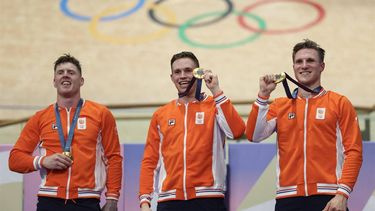 Netherlands' Roy van den Berg (L), Netherlands' Harrie Lavreysen (C) and Netherlands' Jeffrey Hoogland (R) celebrate their gold medal on the podium after winning the men's track cycling team sprint event of the Paris 2024 Olympic Games at the Saint-Quentin-en-Yvelines National Velodrome in Montigny-le-Bretonneux, south-west of Paris, on August 6, 2024. 
Thomas SAMSON / AFP