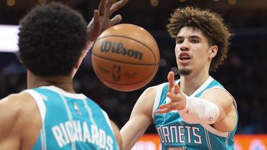 epa09598362 Charlotte Hornets guard LaMelo Ball (R) passes the ball during the first half of the NBA basketball game between the Charlotte Hornets and Washington Wizards, at Capital One Arena in Washington, DC, USA, 22 November 2021.  EPA/MICHAEL REYNOLDS SHUTTERSTOCK OUT