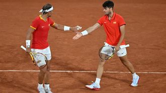 Spain's Carlos Alcaraz (R) and Spain's Rafael Nadal (L) react while they play against Argentina's Maximo Gonzalez and Argentina's Andres Molteni during their men's doubles first round tennis match on Court Philippe-Chatrier at the Roland-Garros Stadium at the Paris 2024 Olympic Games, in Paris on July 27, 2024.  
Miguel MEDINA / AFP