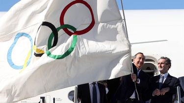 epa09775556 Milan Mayor Giuseppe Sala (2-R) waves the Olympic flag as he disembarks a plane upon arriving from the closing ceremony of the Beijing 2022 Olympic Winter Games, at Malpensa Airport in Milan, Italy, 21 February 2022. Italy will host the XXV Olympic Winter Games, also known as Milano Cortina 2026.  EPA/MATTEO BAZZI