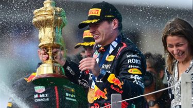 2023-07-09 17:55:16 Winner Red Bull Racing's Dutch driver Max Verstappen holding the trophy reacts as second placed McLaren's British driver Lando Norris sprays champagne during the podium ceremony for the Formula One British Grand Prix at the Silverstone motor racing circuit in Silverstone, central England on July 9, 2023. 
Ben Stansall / AFP