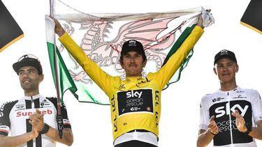 Tour de France 2018 winner Great Britain's Geraint Thomas (C), holds a Welsh flag and the overall leader's yellow jersey, second-placed Netherlands' Tom Dumoulin (L) and third-placed Great Britain's Christopher Froome (R) celebrate on the podium after the 21st and last stage of the 105th edition of the Tour de France cycling race between Houilles and Paris Champs-Elysees, on July 29, 2018.  
Jeff PACHOUD / AFP
