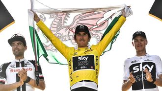 Tour de France 2018 winner Great Britain's Geraint Thomas (C), holds a Welsh flag and the overall leader's yellow jersey, second-placed Netherlands' Tom Dumoulin (L) and third-placed Great Britain's Christopher Froome (R) celebrate on the podium after the 21st and last stage of the 105th edition of the Tour de France cycling race between Houilles and Paris Champs-Elysees, on July 29, 2018.  
Jeff PACHOUD / AFP