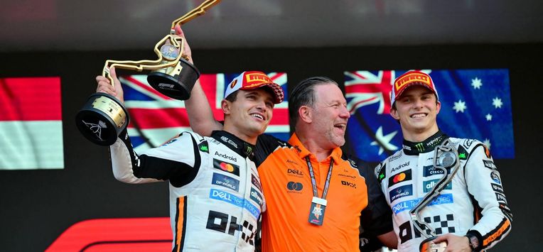 McLaren's British driver Lando Norris (L) lifts his trophy in the air as he celebrates winning the Formula One Monaco Grand Prix on the podium with McLaren's CEO Zak Brown (C) and third-placed McLaren's Australian driver Oscar Piastri (R) at the Circuit de Monaco, on May 25, 2025. 
Andrej ISAKOVIC / AFP