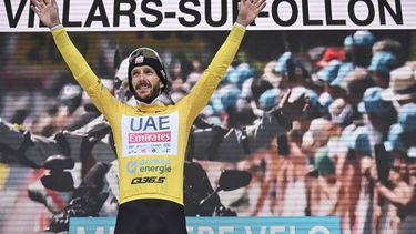 epa11412680 Adam Yates from Great Britain of UAE Team Emirates, retaining the overall leader's yellow jersey, celebrates on the podium after the Tour de Suisse's seventh stage, a 118.2km cycling race from Villars-sur-Ollon to Villars-sur-Ollon, Switzerland, 15 June 2024.  EPA/GIAN EHRENZELLER