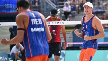 Netherlands' #01 Steven Van De Velde and Netherlands' #02 Matthew Immers celebrate a point in the men's pool B beach volleyball match between Netherlands and Chile during the Paris 2024 Olympic Games at the Eiffel Tower Stadium in Paris on July 31, 2024. 
Kirill KUDRYAVTSEV / AFP