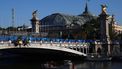 A Paris' Anita Conti boat is navigated along the Seine river under the Alexandre III bridge with the Grand Palais in the background ahead of the Paris 2024 Olympic and Paralympic Games in Paris on July 22, 2024.  
EMMANUEL DUNAND / AFP