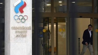 A man walks past the logo of the Russian Olympic Committee (ROC) as he leaves the office in Moscow on October 15, 2024. The head of Russia's Olympic Committee announced his resignation on October 15, 2024, a surprise move that comes as Moscow faces isolation from international sport over its Ukraine offensive. Former fencer, Stanislav Pozdnyakov, a five-time Olympic medallist, said in his resignation letter there were 