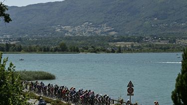The pack of riders (peloton) cycles past Lac du Bourget lake at the start of the 17th stage of the 113th edition of the Tour de France cycling race, 174,7 km between Chambéry and Voiron in the French Alps, on July 22, 2026. 
Loic VENANCE / AFP