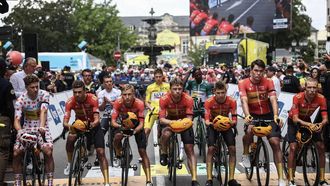 Uno-X Mobility team riders wearing a black armband to symbolize mourning, line up at the start of the 9th stage of the 111th edition of the Tour de France cycling race, 199km stage departing and finishing in Troyes, on July 7, 2024 to pay tribute to their compatriot, Team Coop-Repsol's Norwegian rider Andre Dege who died in a crash on day prior on the Tour of Austria cycling race. 
Anne-Christine POUJOULAT / AFP