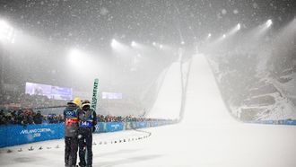epa12747915 Andreas Wellinger (L) and Philipp Raimund (R) of Germany move in the finish area during the Men's Super Team, final round, of the Ski Jumping competitions at the Milano Cortina 2026 Winter Olympic Games, in Predazzo, Italy, 16 February 2026.  EPA/HANNIBAL HANSCHKE