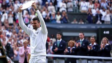 Second-placed Serbia's Novak Djokovic lifts his price following his defeat against Spain's Carlos Alcaraz during their men's singles final tennis match on the fourteenth day of the 2024 Wimbledon Championships at The All England Lawn Tennis and Croquet Club in Wimbledon, southwest London, on July 14, 2024. Defending champion Alcaraz beat seven-time winner Novak Djokovic in a blockbuster final, with Alcaraz winning 6-2, 6-2, 7-6. 
HENRY NICHOLLS / AFP