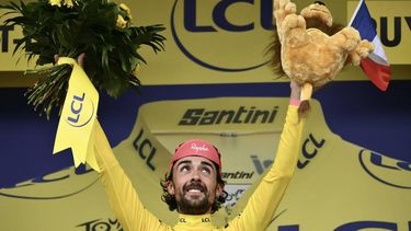 Guest and EF Education - EasyPost team's Irish rider Ben Healy celebrates on the podium with the overall leader's yellow jersey after the 10th stage of the 112th edition of the Tour de France cycling race, 165.3 km between Ennezat and Le Mont-Dore Puy de Sancy, in central France, on July 14, 2025. 
Marco BERTORELLO / AFP