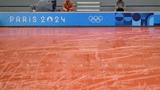 Spectators take shelter from the rain as the wet weather delays the start of play on the outside courts at the Roland-Garros Stadium at the Paris 2024 Olympic Games, in Paris on July 27, 2024.  
Patricia DE MELO MOREIRA / AFP