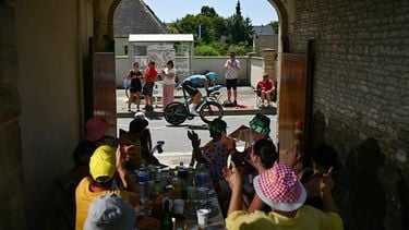 XDS Astana Team's Dutch rider Cees Bol cycles past spectators eating at a table along the race route during the 5th stage of the 112th edition of the Tour de France cycling race, 33 km individual time trial starting and finishing in Caen, northwestern France, on July 9, 2025. 
Loic VENANCE / AFP