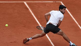 Spain's Carlos Alcaraz plays a backhand return to Italy's Giulio Zeppieri during their men's singles match on day 2 of the French Open tennis tournament on Court Suzanne-Lenglen at the Roland-Garros Complex in Paris on May 26, 2025. 
Franck FIFE / AFP