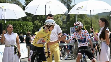 UAE Team Emirates - XRG's Slovenian rider Tadej Pogacar wearing the overall leader's yellow jersey shakes hands with Soudal Quick-Step team's French rider Valentin Paret-Peintre wearing the climber's dotted 