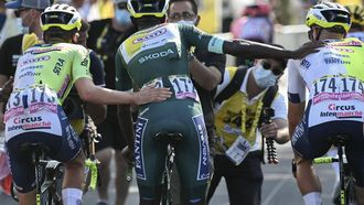 Intermarche - Wanty team's Eritrean rider Biniam Girmay wearing the sprinter's green jersey is assisted by teammates as he cycles past the finish line after crashing in the final kilometers of the 16th stage of the 111th edition of the Tour de France cycling race, 188,6 km between Gruissan and Nimes, southern France, on July 16, 2024. 
Marco BERTORELLO / AFP