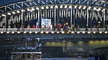 The delegations from Niger, Nigeria and Norway sails under a bridge as models display creations during the opening ceremony of the Paris 2024 Olympic Games in Paris on July 26, 2024, as the Eiffel Tower is seen in the background. 
Paul ELLIS / AFP