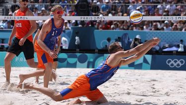 Netherlands' #02 Yorick De Groot dives to reach the ball beside his partner Netherlands' #01 Stefan Boermans as Czech Republic's #01 Ondrej Perusic watches in their men's round of 16 beach volleyball match between Czech Republic and Netherlands during the Paris 2024 Olympic Games at the Eiffel Tower Stadium in Paris on August 4, 2024. 
Thomas SAMSON / AFP