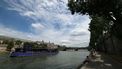 People sit on the banks of the Seine river as a boat passes by in Paris, on July 11, 2024. 
EMMANUEL DUNAND / AFP