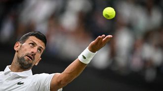 Serbia's Novak Djokovic serves the ball to Denmark's Holger Rune during their men's singles tennis match on the eighth day of the 2024 Wimbledon Championships at The All England Lawn Tennis and Croquet Club in Wimbledon, southwest London, on July 8, 2024. 
Ben Stansall / AFP