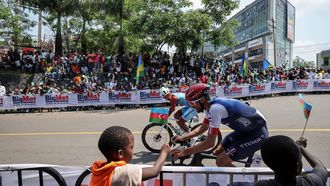 Mongolian rider Tegshbayar Batsaikhan (L) and French rider Julian Alaphilippe (R) competes in the men's Elite road race cycling event during the UCI 2025 Road World Championships, in Kigali, on September 28, 2025. 
Anne-Christine POUJOULAT / AFP