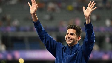 Bronze medallist US' Grant Fisher celebrates on the podium after competing in the men's 5000m final of the athletics event during the Paris 2024 Olympic Games at Stade de France in Saint-Denis, north of Paris, on August 10, 2024. 
MARTIN BERNETTI / AFP