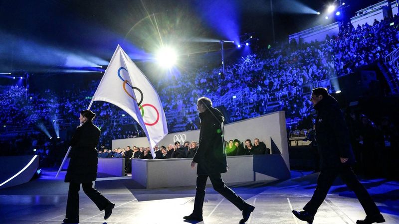Milan mayor Giuseppe Sala (C) and Cortina d'Ampezzo mayor Gianluca Lorenzi (R) walk behind the Olympic flag during the flag handover ceremony at the closing ceremony of the Milano Cortina 2026 Winter Olympic Games at the Verona Arena in Verona, northern Italy, on February 22, 2026. 
Stefano RELLANDINI / AFP