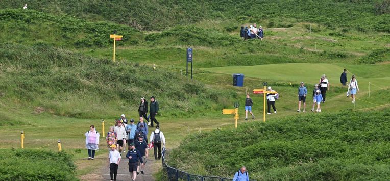 Spectators make their way off the course as practice is suspended due to the weather ahead of the 153rd Open Championship at Royal Portrush golf club in Northern Ireland on July 14, 2025. 
ANDY BUCHANAN / AFP