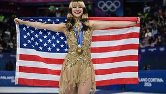 Gold medallist USA's Alysa Liu holds her country's flag after the victory ceremony of the figure skating women's single free skating final during the Milano Cortina 2026 Winter Olympic Games at Milano Ice Skating Arena in Milan on February 19, 2026. 
Gabriel BOUYS / AFP