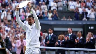 Second-placed Serbia's Novak Djokovic lifts his price following his defeat against Spain's Carlos Alcaraz during their men's singles final tennis match on the fourteenth day of the 2024 Wimbledon Championships at The All England Lawn Tennis and Croquet Club in Wimbledon, southwest London, on July 14, 2024. Defending champion Alcaraz beat seven-time winner Novak Djokovic in a blockbuster final, with Alcaraz winning 6-2, 6-2, 7-6. 
HENRY NICHOLLS / AFP