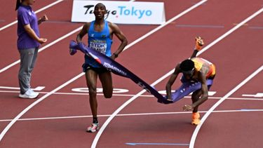Tanzania's athlete Alphonce Felix Simbu and Germany's athlete Amanal Petros (R) cross the finish line in the men's marathon final during the World Athletics Championships in Tokyo on September 15, 2025. 
Jewel SAMAD / AFP