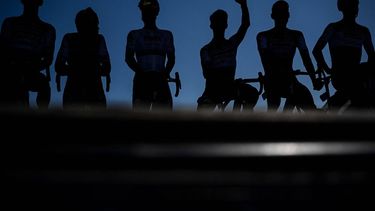 2023-07-09 12:39:47 Lotto Dstny team riders are silhouetted as they wave to spectators from the stage before the start of the 9th stage of the 110th edition of the Tour de France cycling race, 182,5 km between Saint-Leonard-de-Noblat and Puy de Dome, in central France, on July 9, 2023. 
Marco BERTORELLO / AFP