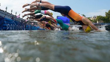 Athletes dive into the Seine river as they start the swimming stage of the men's individual triathlon at the Paris 2024 Olympic Games in central Paris on July 31, 2024. 
David Goldman / POOL / AFP