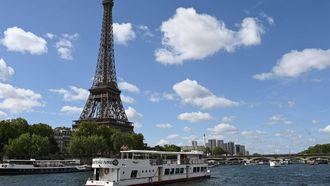 2023-07-17 11:21:31 A Peniche boat sails past the Eiffel Tower on the River Seine on July 17, 2023, during a parade to test 