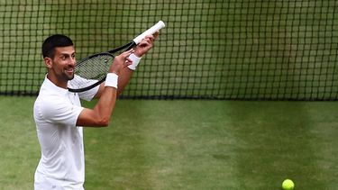 Serbia's Novak Djokovic imitates playing the violin with his racquet as he celebrates winning against Italy's Lorenzo Musetti during their men's singles semi-final tennis match on the twelfth day of the 2024 Wimbledon Championships at The All England Lawn Tennis and Croquet Club in Wimbledon, southwest London, on July 12, 2024. Djokovic won the match 6-4, 7-6, 6-4.
HENRY NICHOLLS / AFP