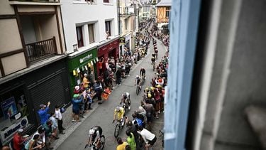 The pack of riders (peloton) cycles through the town of Arreau during the 14th stage of the 112th edition of the Tour de France cycling race, 182.6 km between Pau and Luchon-Superbagneres, in the Pyrenees mountains of southwestern France, on July 19, 2025. 
Loic VENANCE / AFP